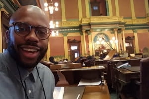 Teacher Mario Pritchard sitting at desk in state Legislature chambers Teacher Mario Pritchard sitting at desk in state Legislature chambers