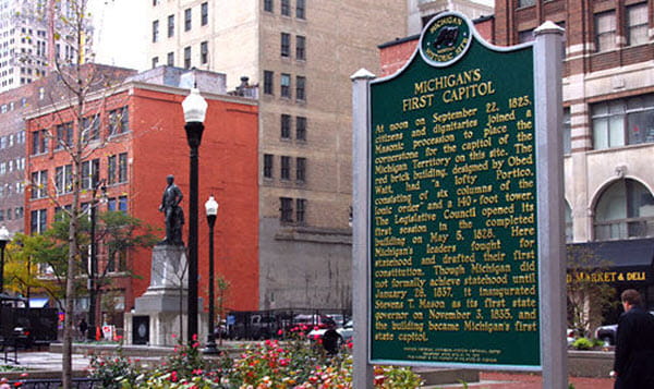 Michigan's First Capitol marker closeup also shows nearby buildings, Stevens T Mason bronze statue