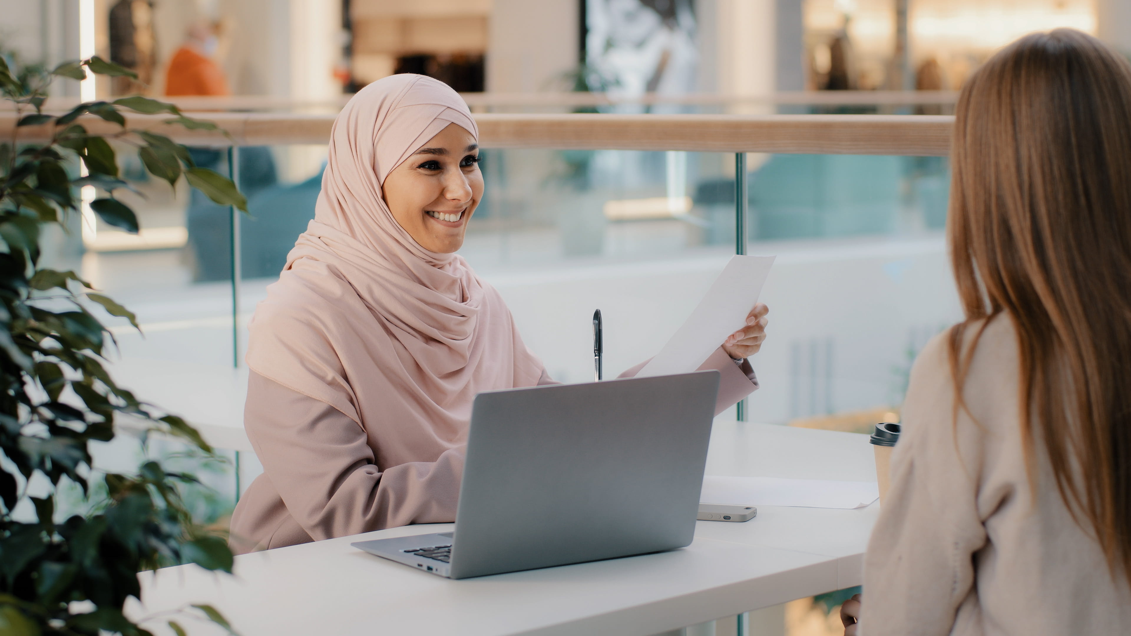 Young Arab-woman reviewing paper documents and computer files