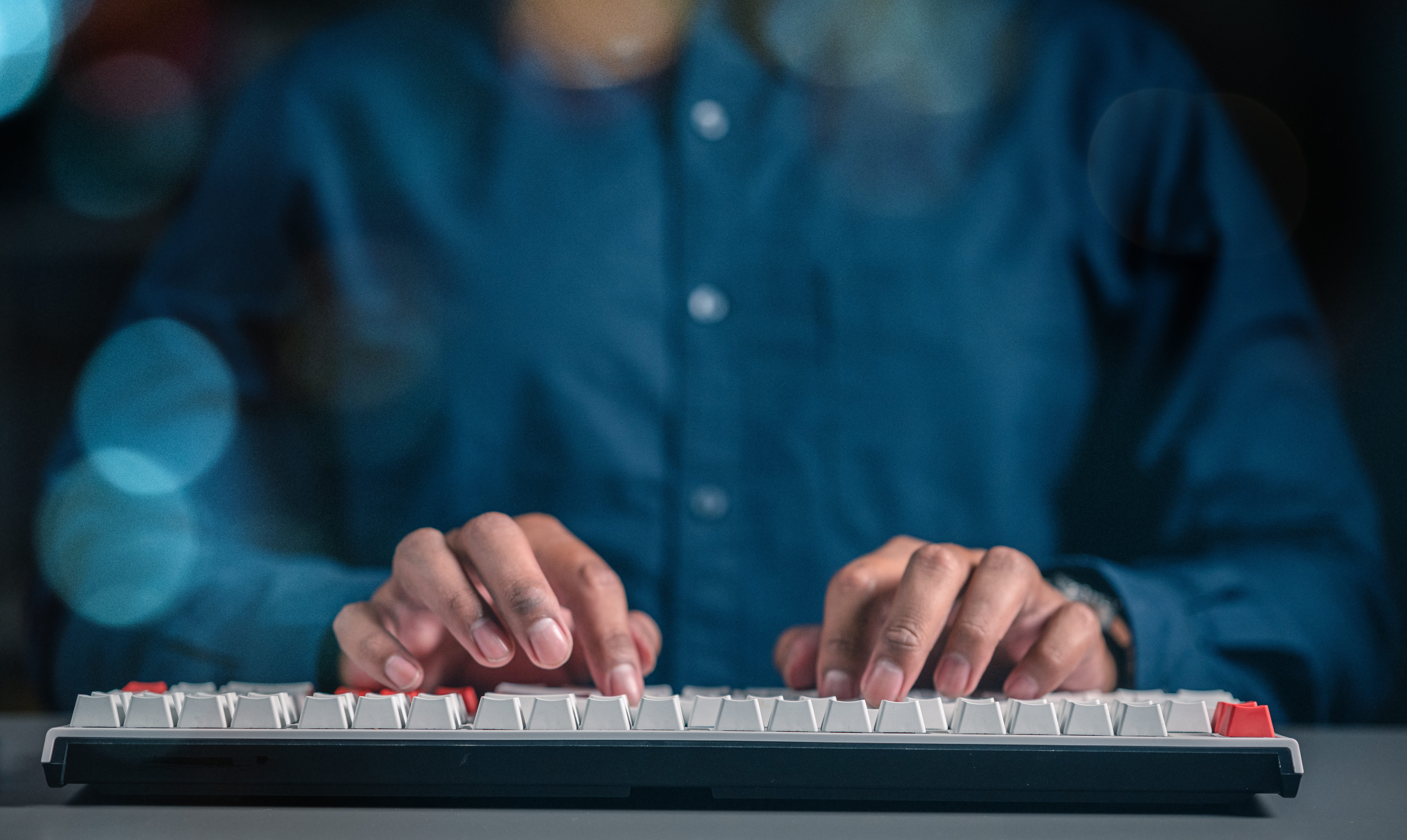 Male using a keyboard to enter data into a computer program