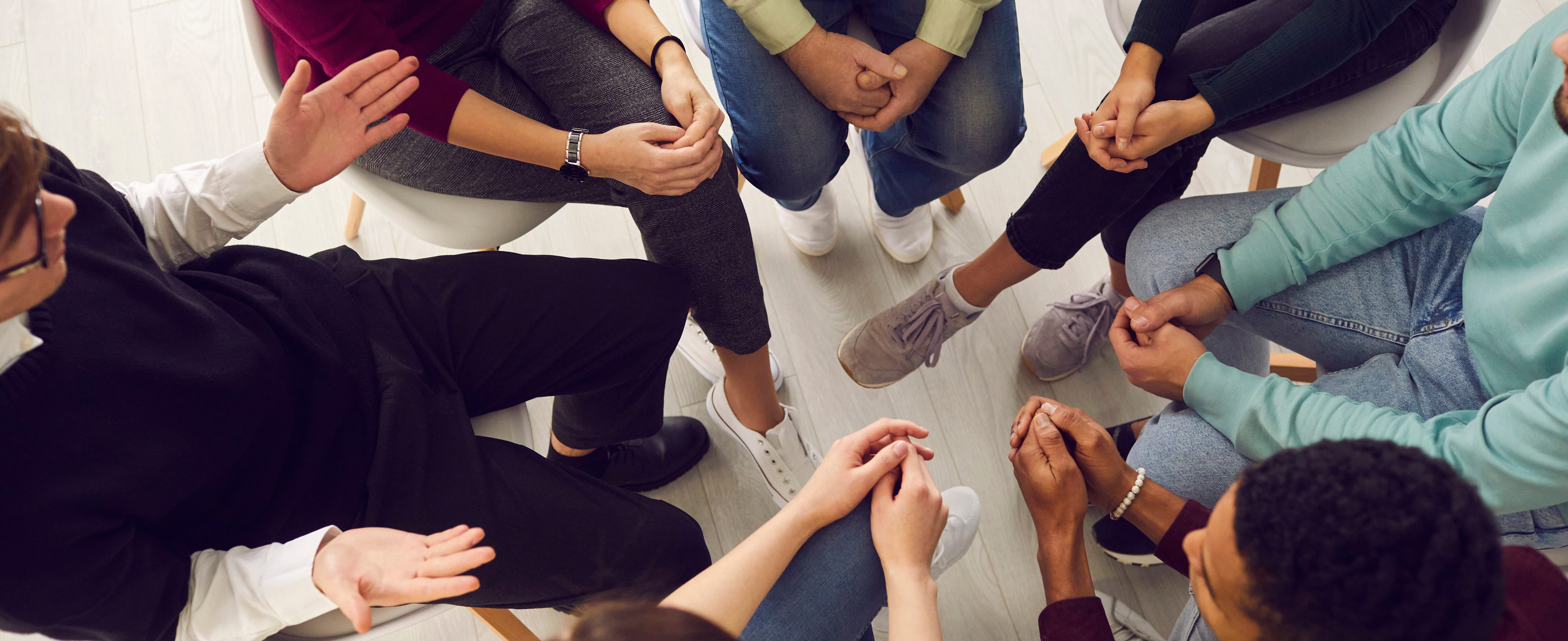 Top view of diverse people sitting in a close circle and talking 