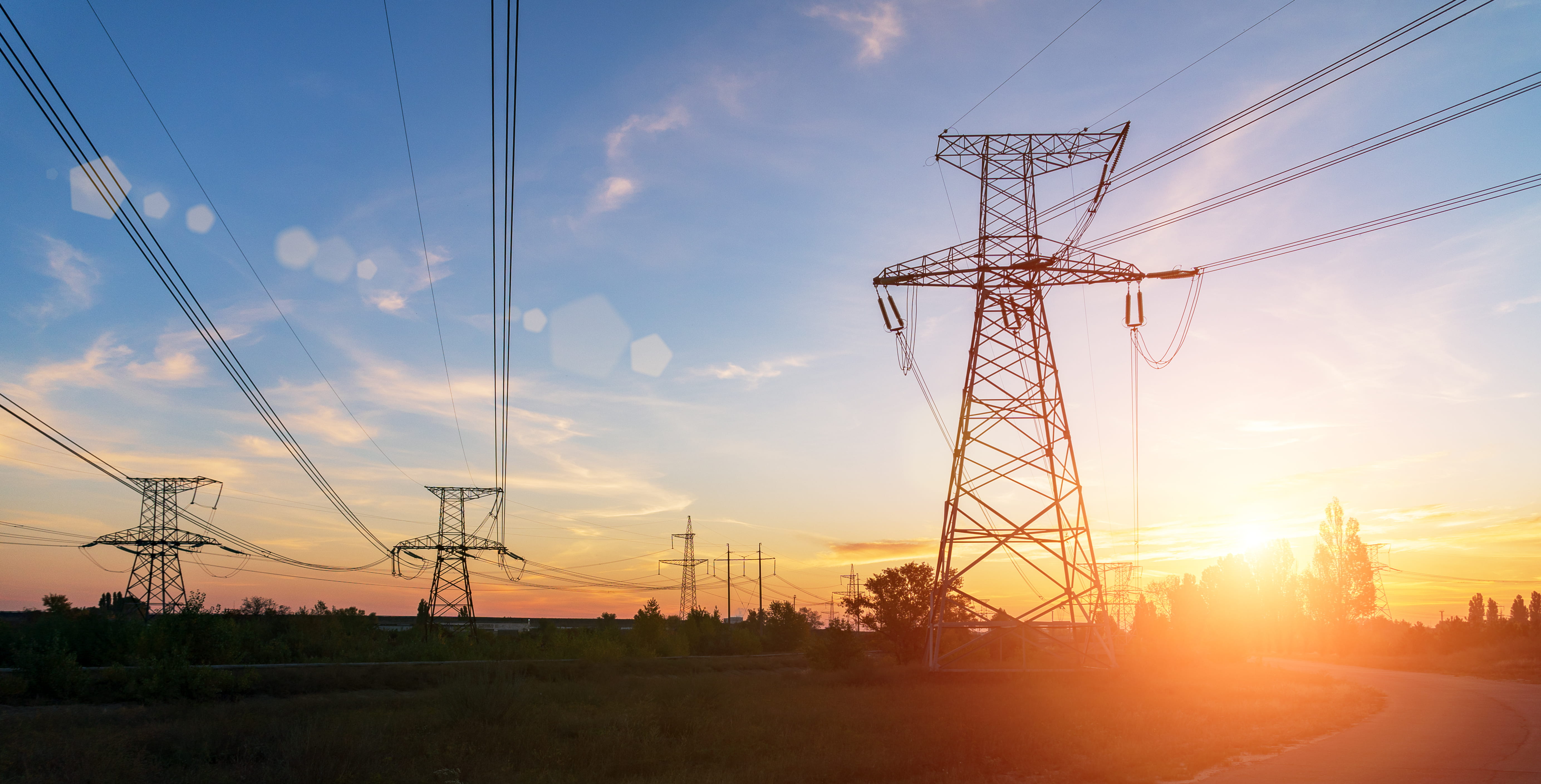 High-voltage power lines at sunset. Electricity distribution station. 