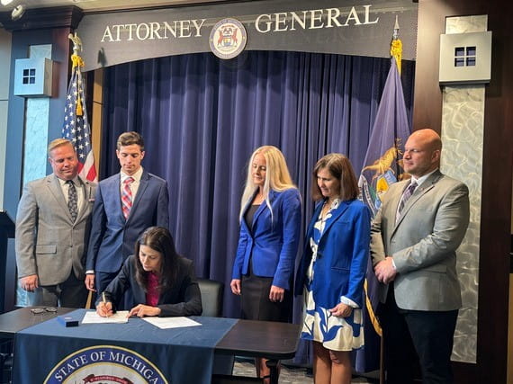 Michigan Attorney General Dana Nessel signs Senate Bill 602 into law as acting governor. Nessel was joined by members of the Michigan Realtors, representatives of the Department of Attorney General, and her son.