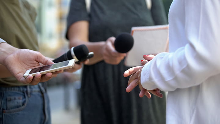 Woman talking during interview with media, press conference, close-up