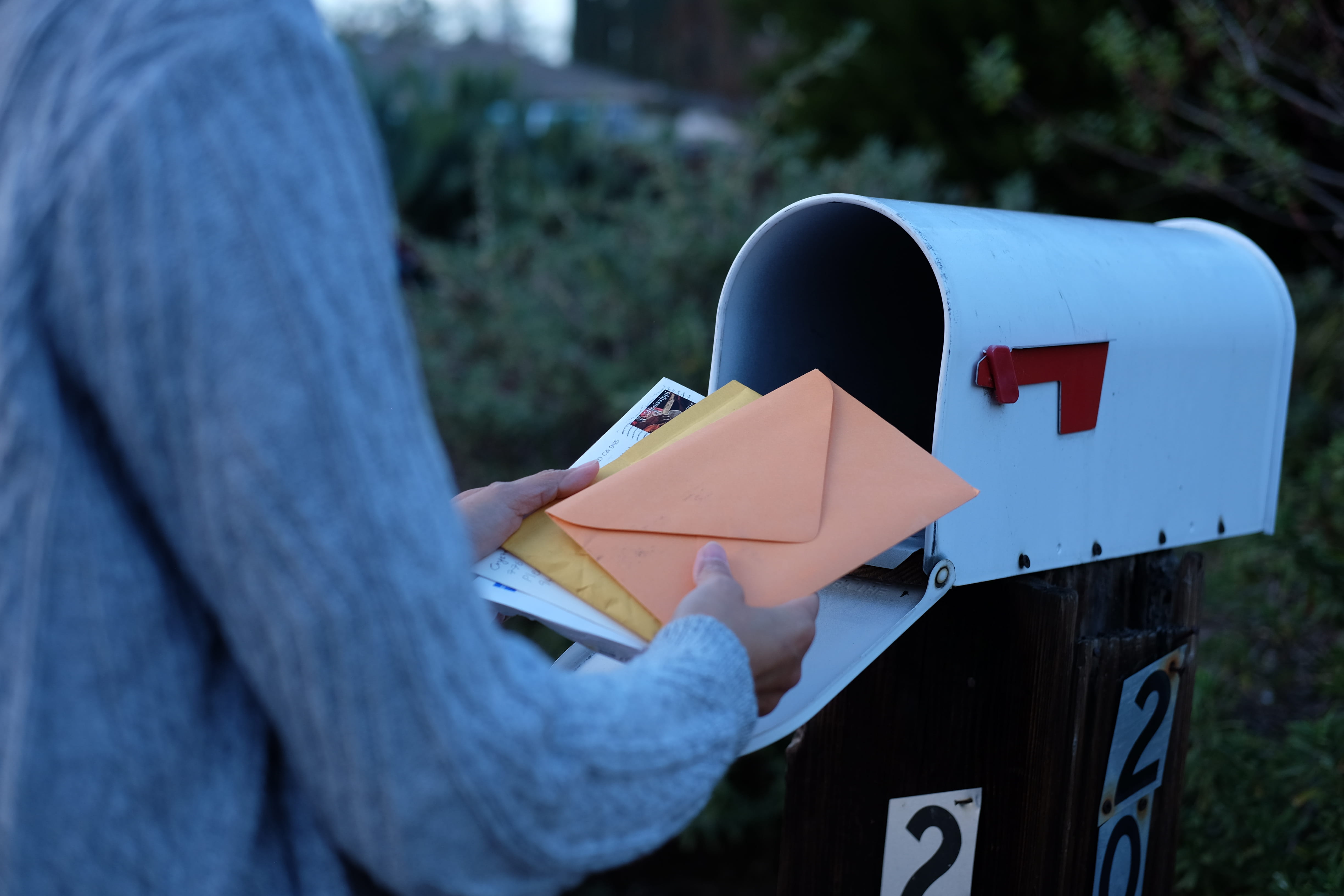 Woman collect mails from a mailbox.