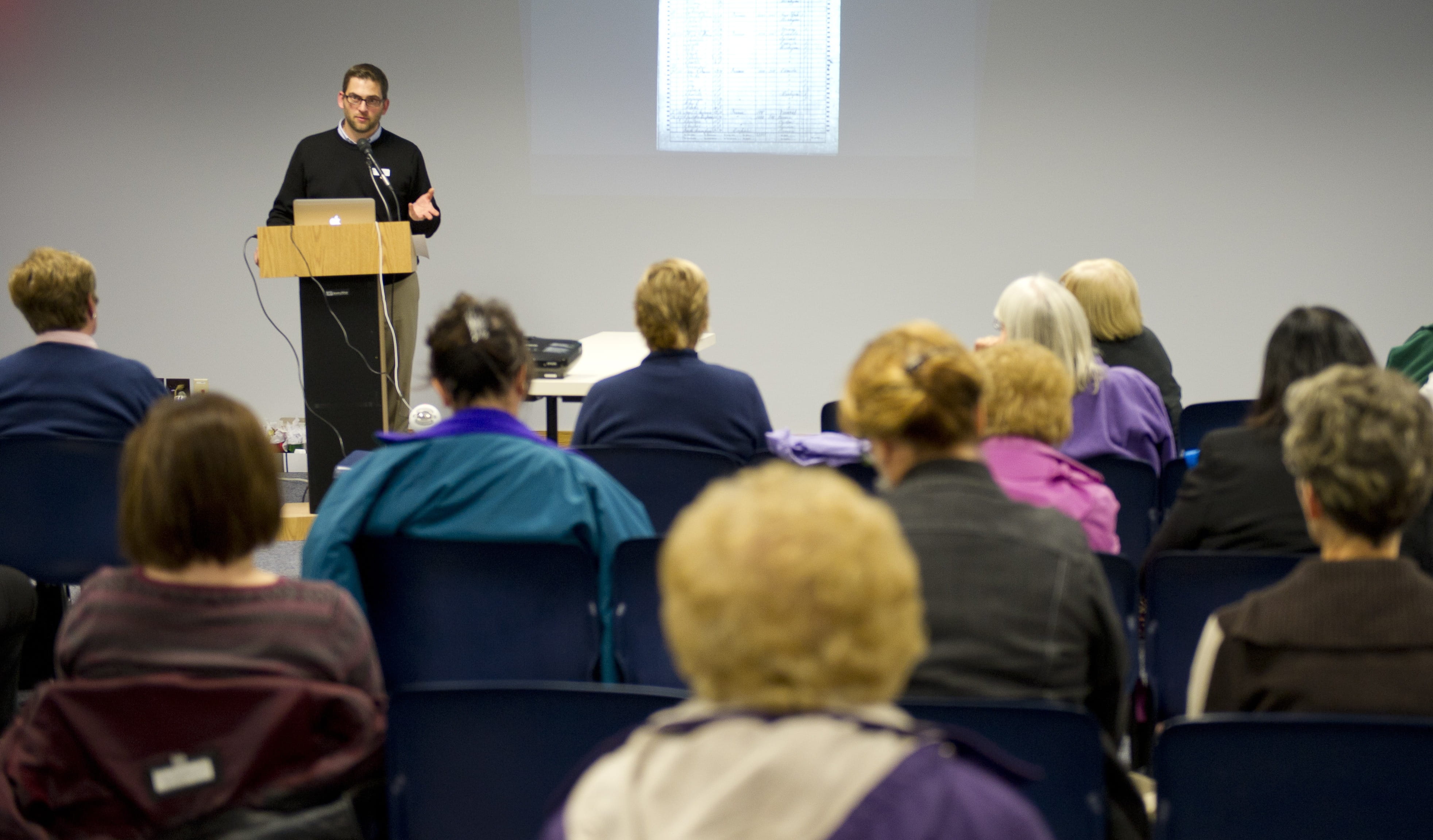 A man giving a presentation to a room full of people.