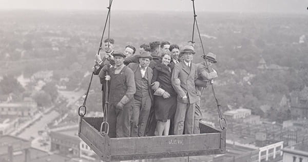 A group of people standing on a platform high above a city.