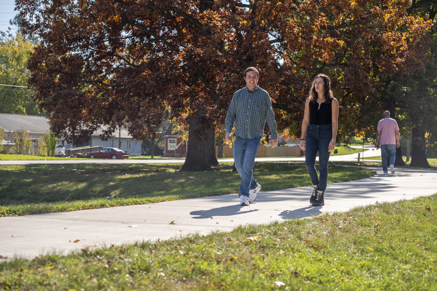 Two employees walking on an outdoor pathway.