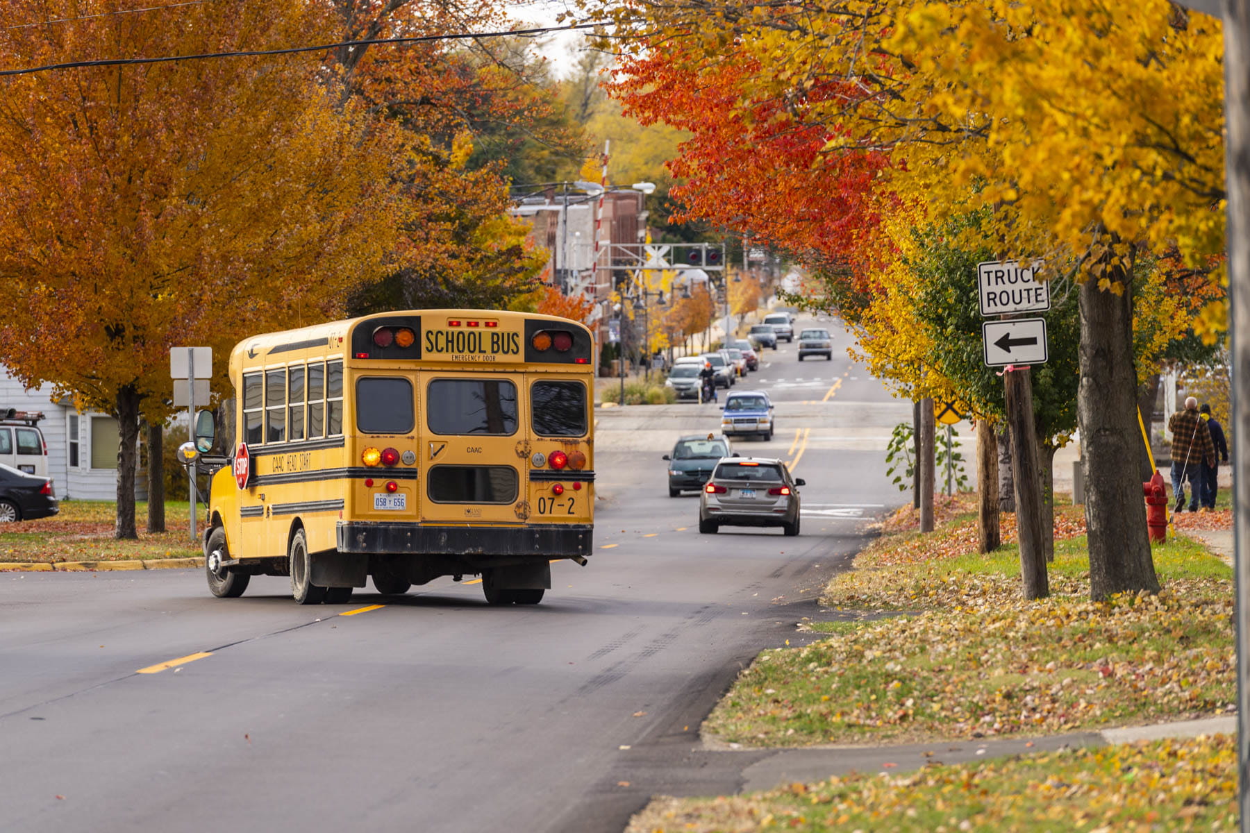 A school bus driving down a neighborhood street.