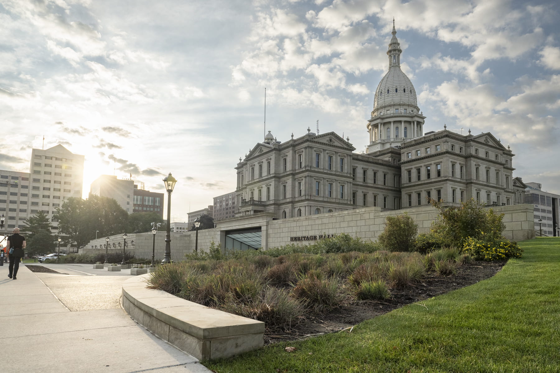 Michigan's state capitol building, towering above a green lawn.