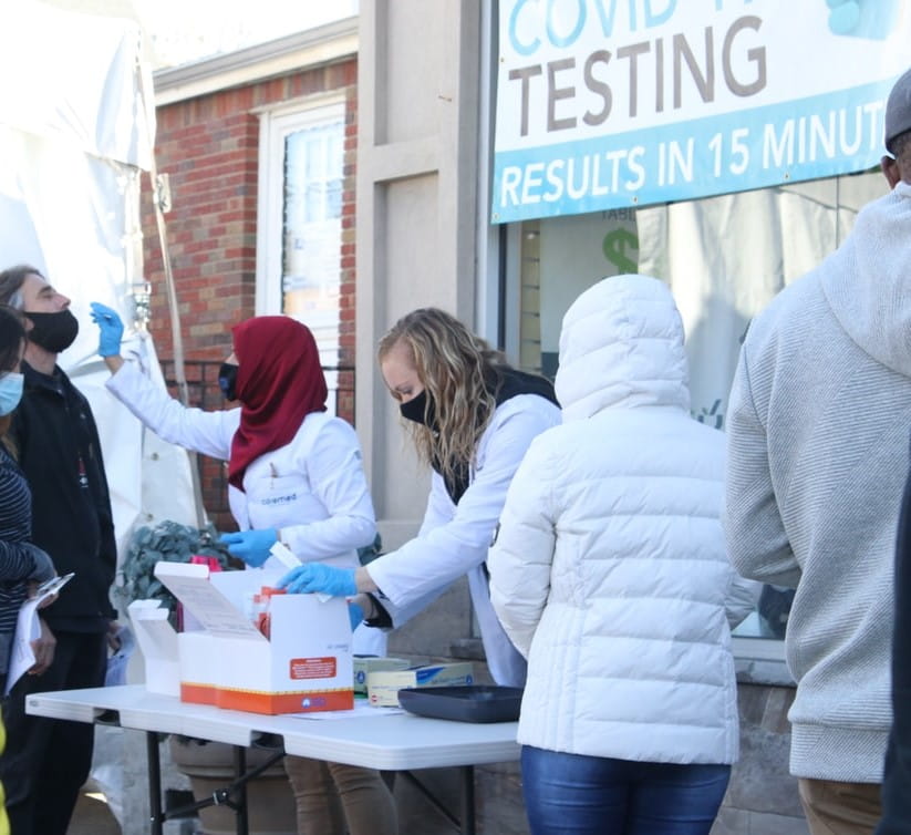 Group of people getting tested for COVID at outdoor clinic