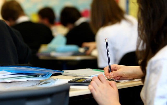 Student writing in classroom