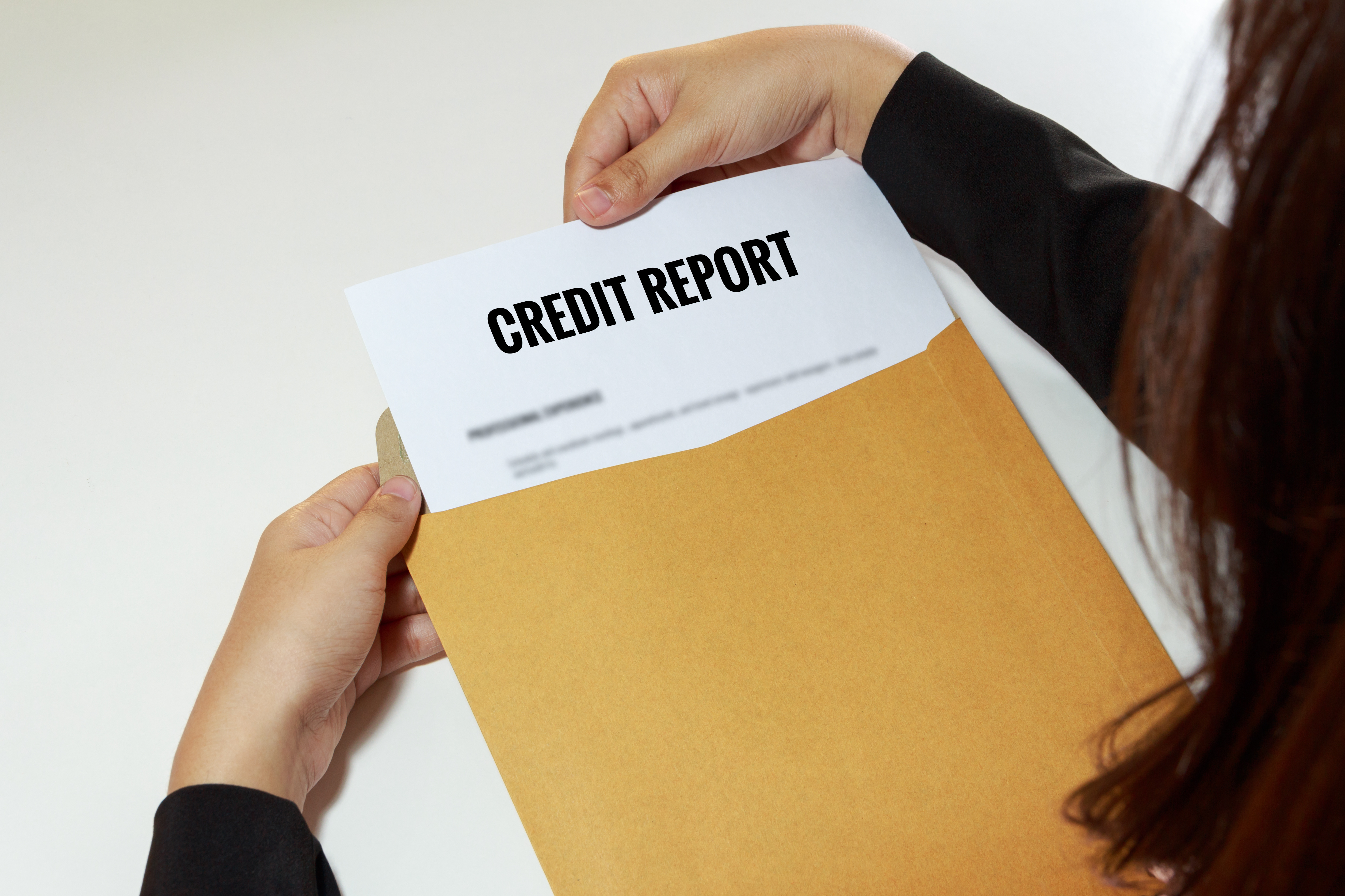 Woman pulling her credit report out of a manilla envelope