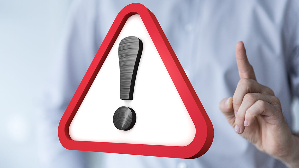 Person holding their index finger up in warning, with a warning icon in the middle of the screen