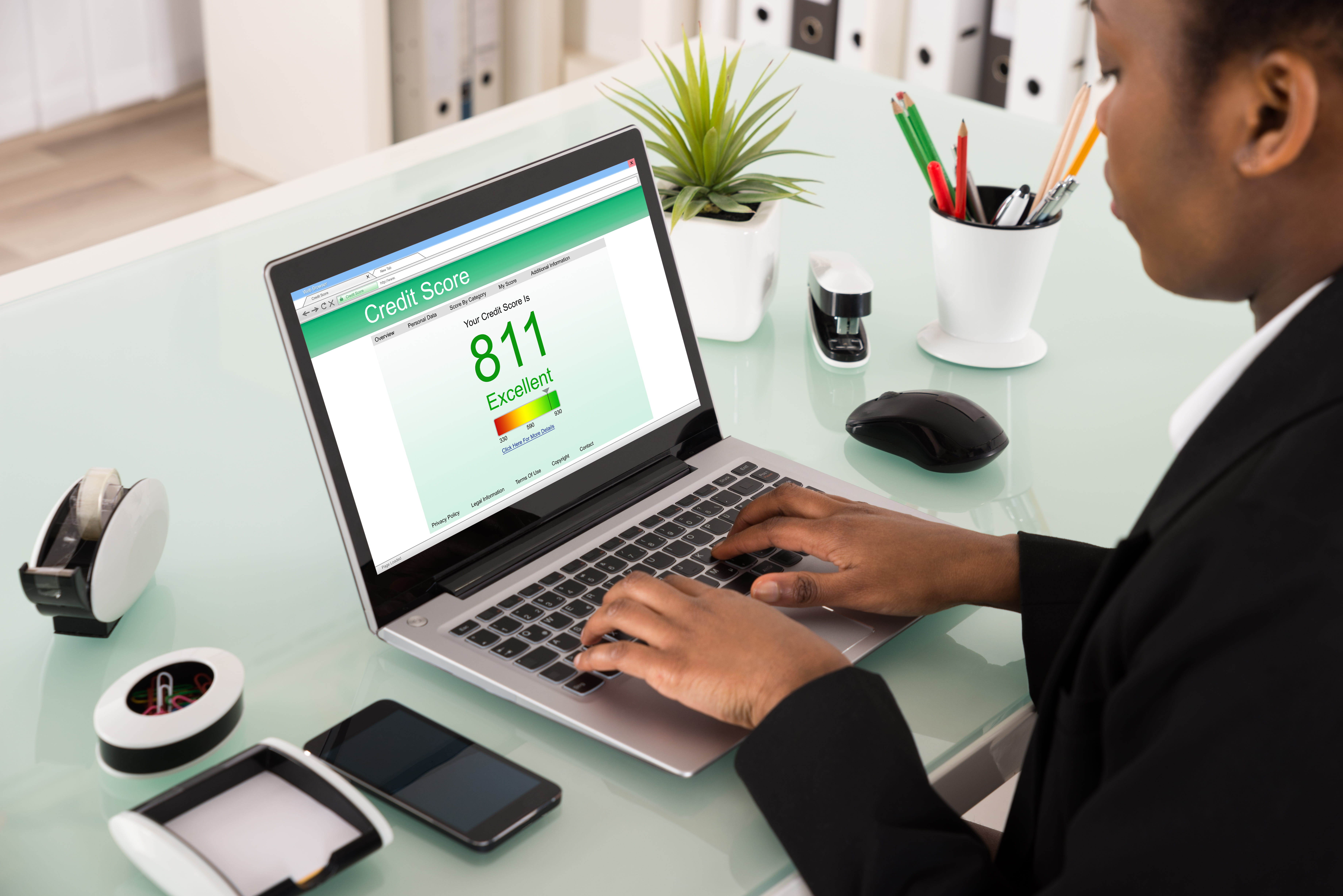 Black woman reviewing her 811 credit report on laptop computer