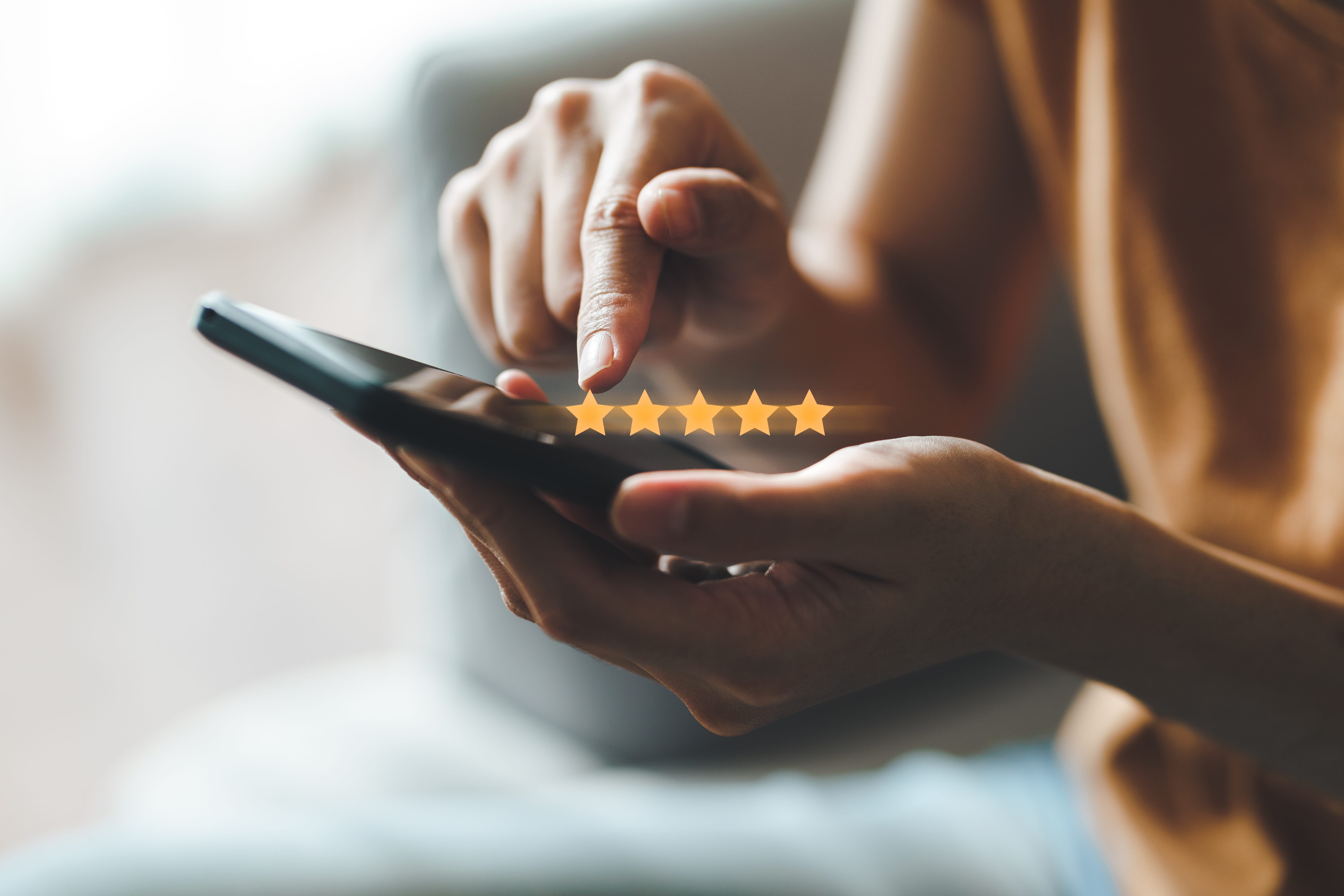 Close up of woman customer giving a five star rating on smartphone