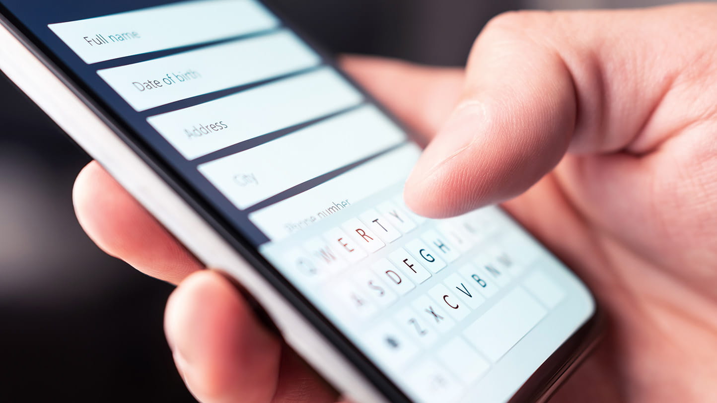 Person typing information into an online form on their smartphone