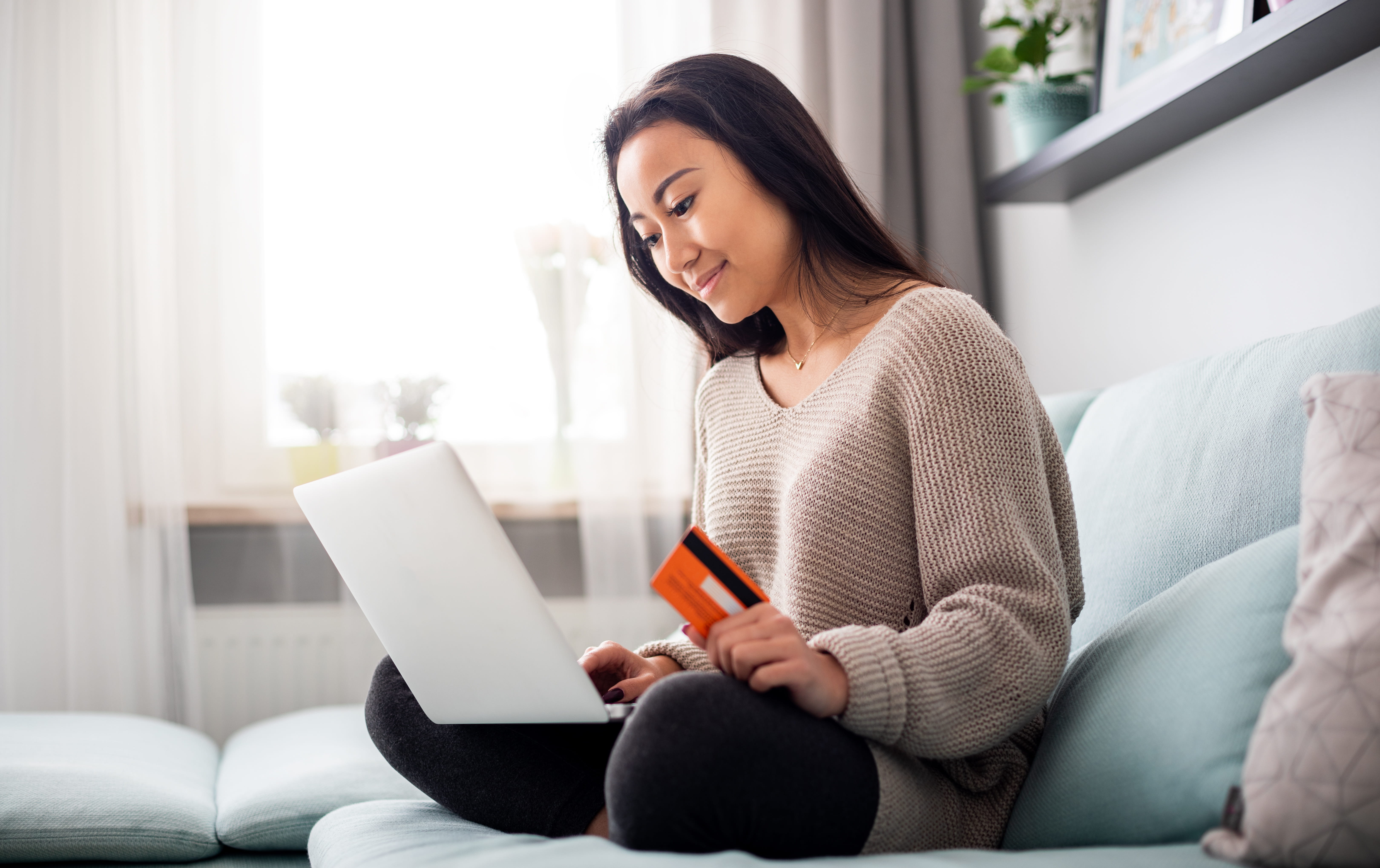 Asian girl making using laptop for shopping at home