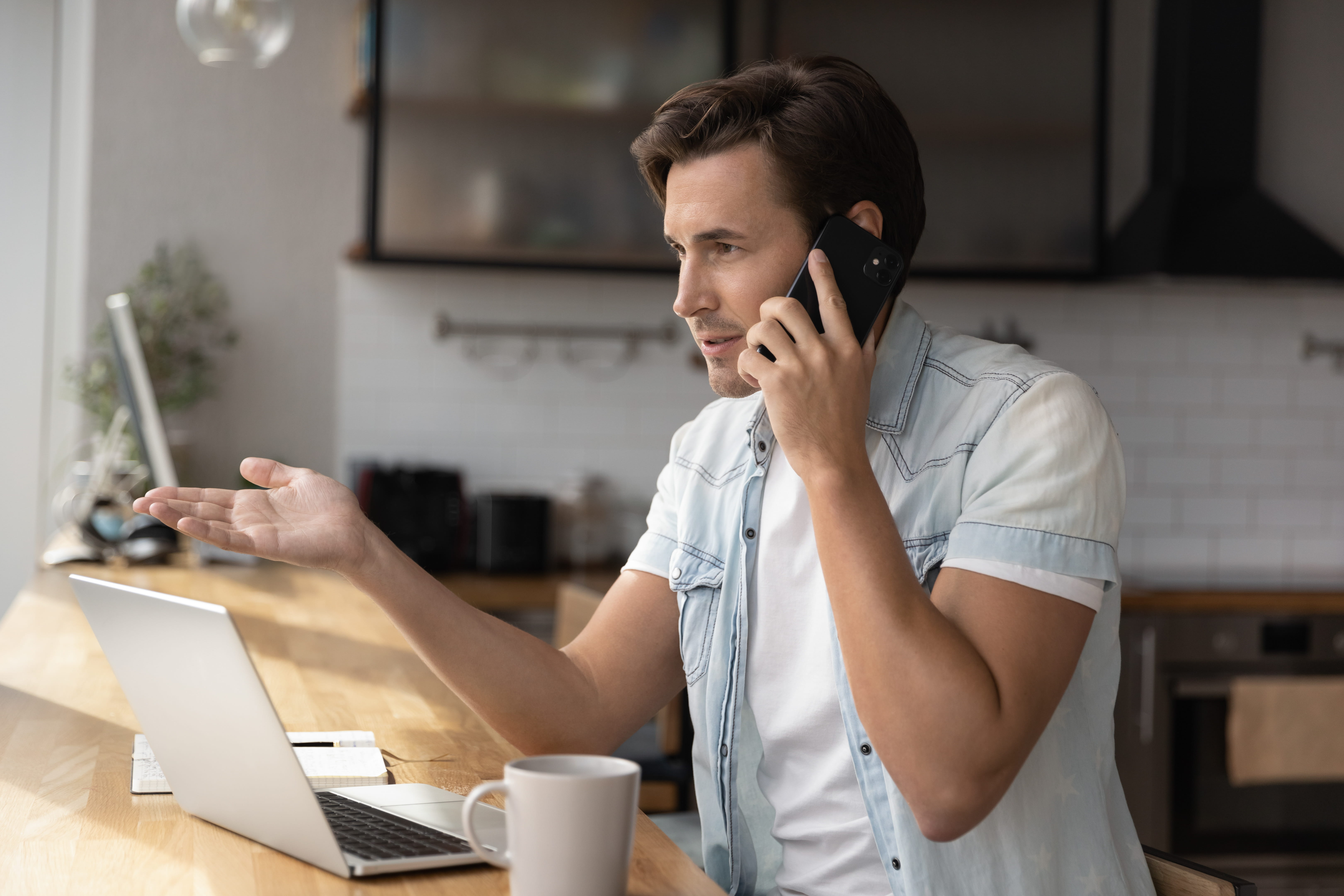Concentrated young man employee manager involved in phone call conversation