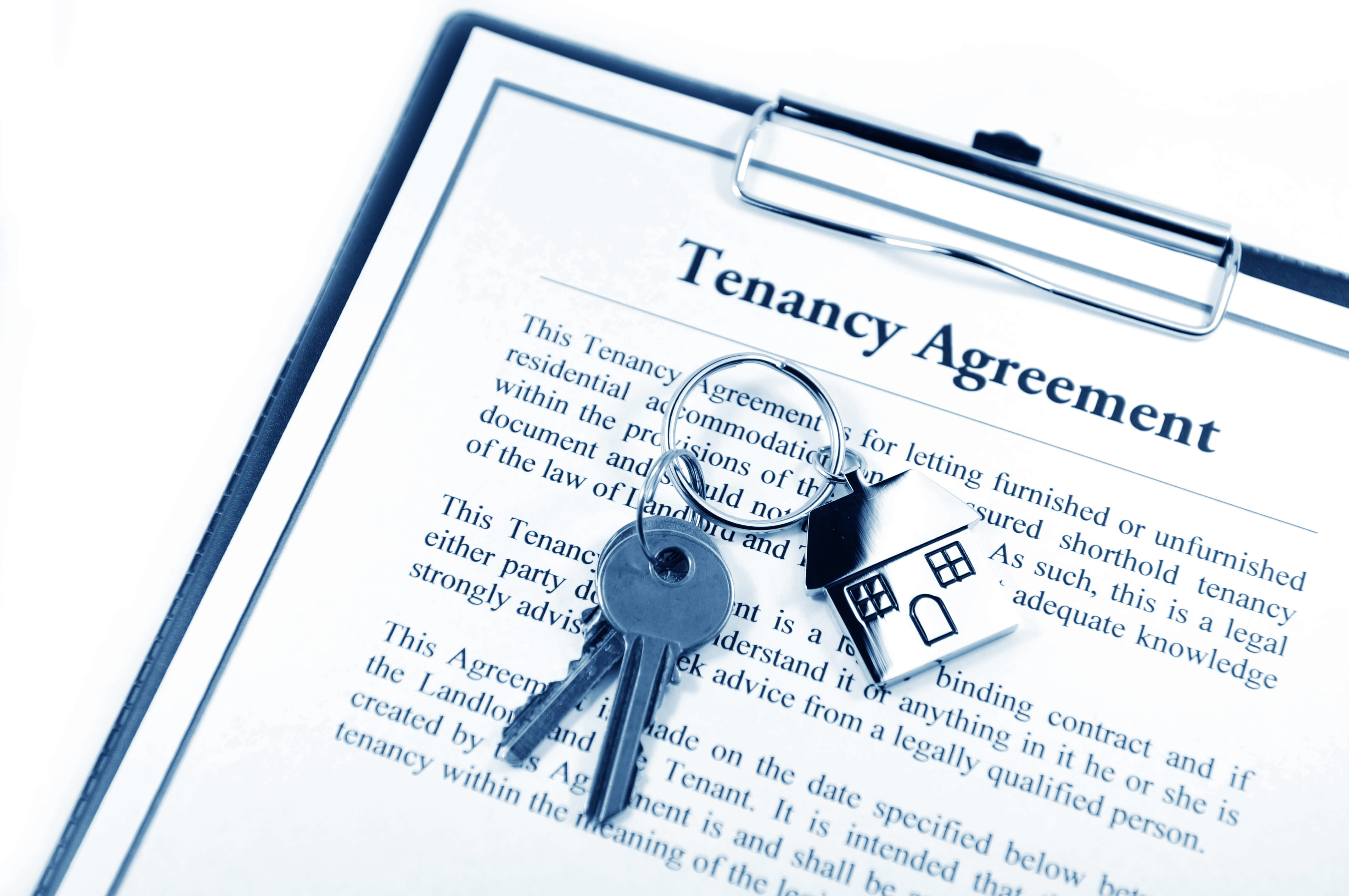 Tenancy Agreement contract on clipboard with the keys sitting on top