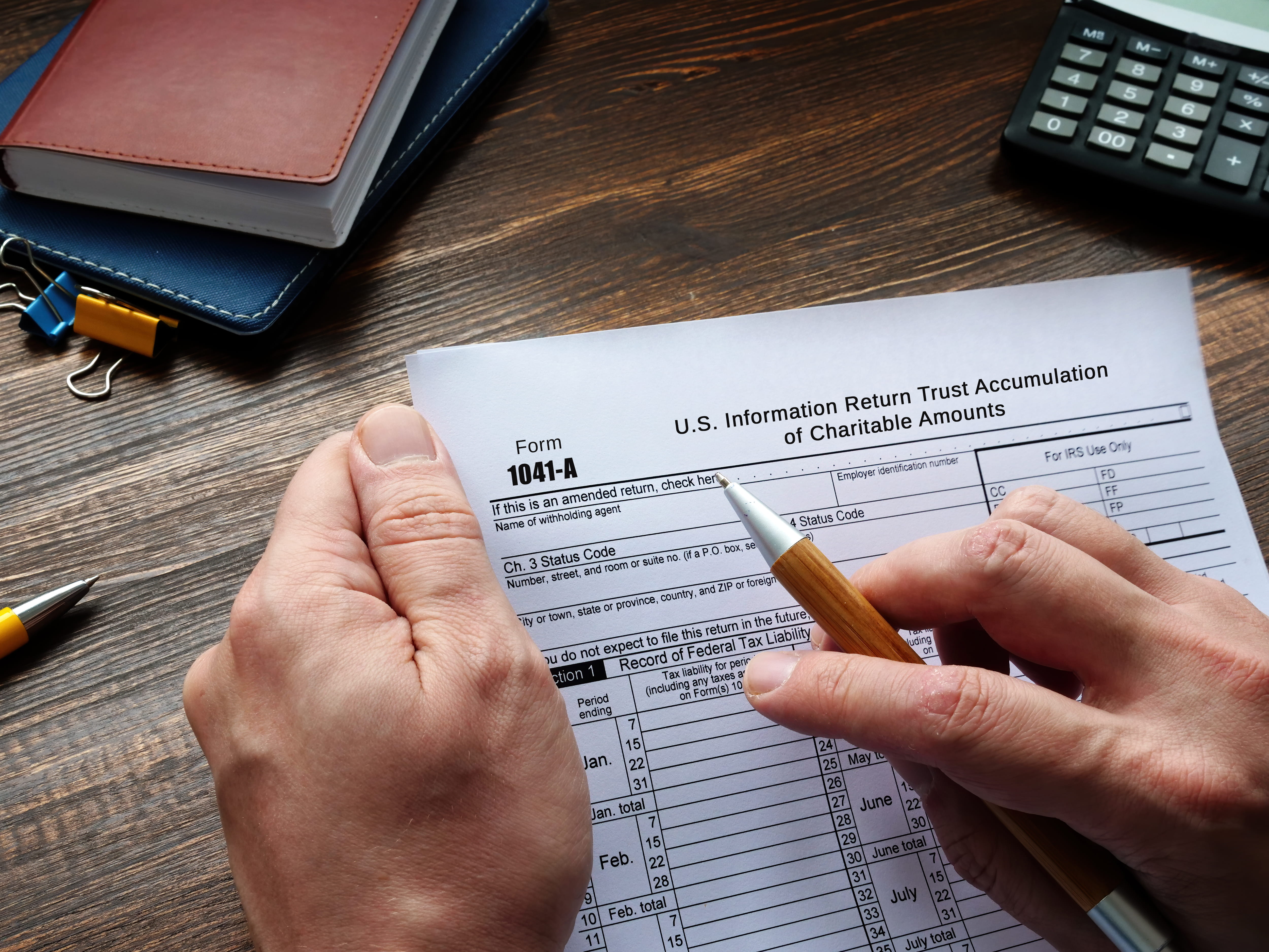 Person reviewing the IRS Form 1041-A U.S. Information Return Trust Accumulation of Charitable Amounts sheet