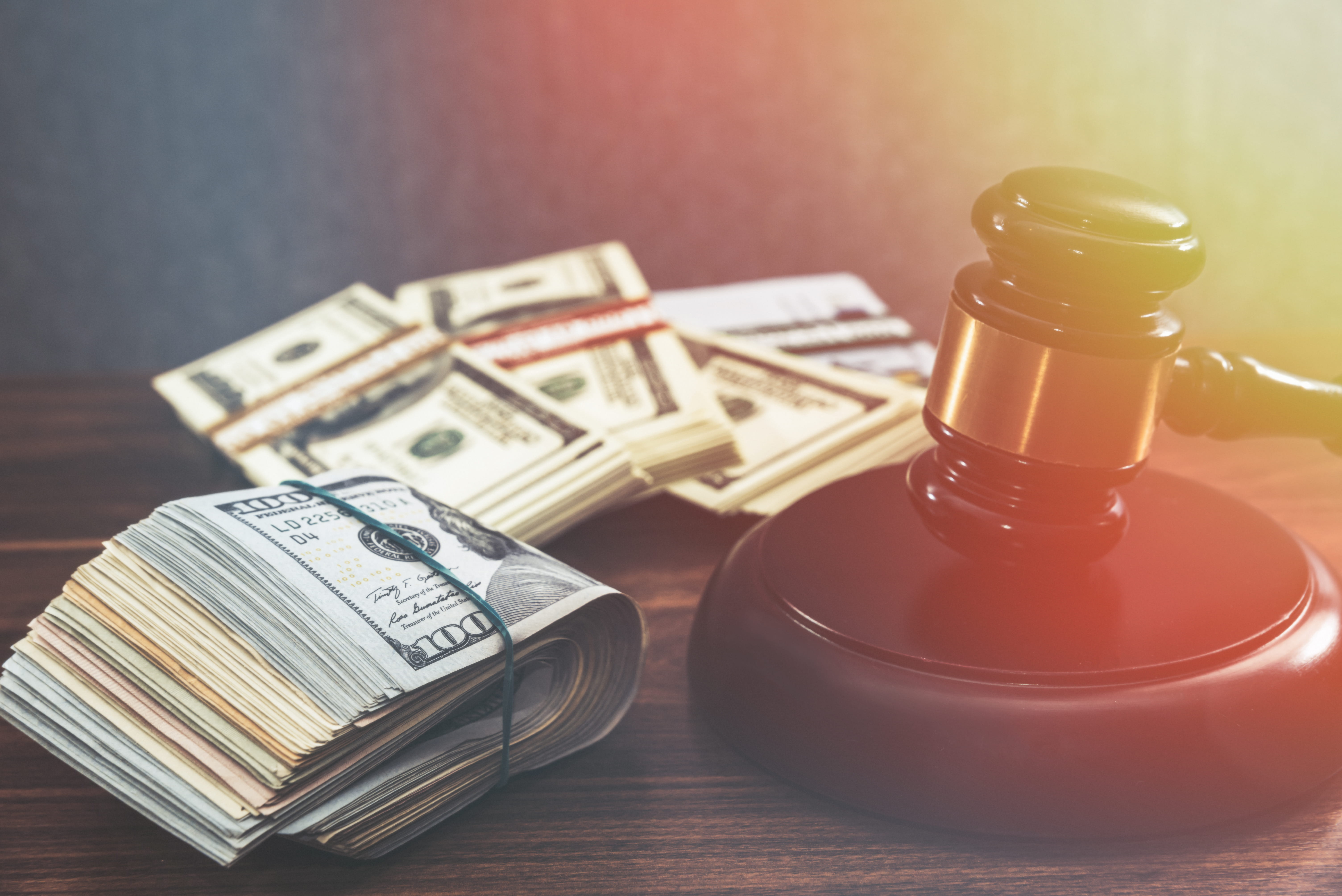 wooden gavel/hammer with rubber-band wrapped $100 dollar bills.