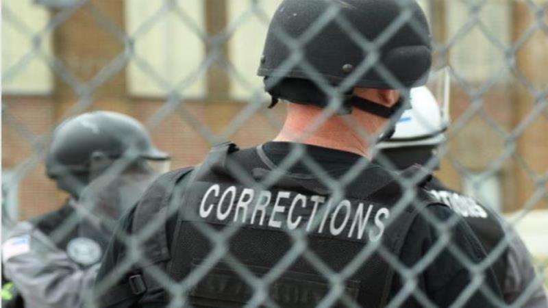 Image of MDOC ERT member standing inside a fence 
