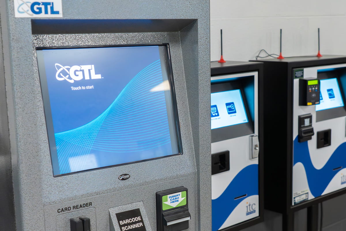 A digital kiosk with the letters GTL displayed on the screen.