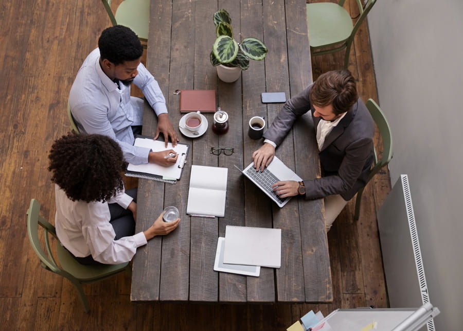 Three people gathered at a table discussing a topic