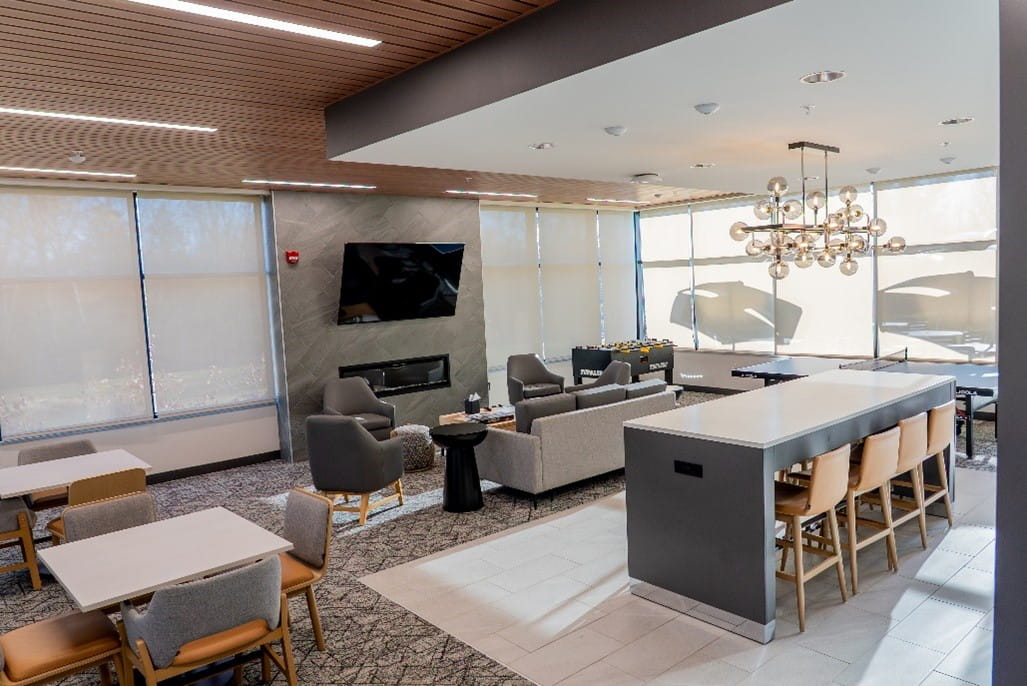 The recreation area at Green Oaks Training and Professional Development Center. A couch and several arm chairs are in the room along with a flat screen tv mounted on the wall.