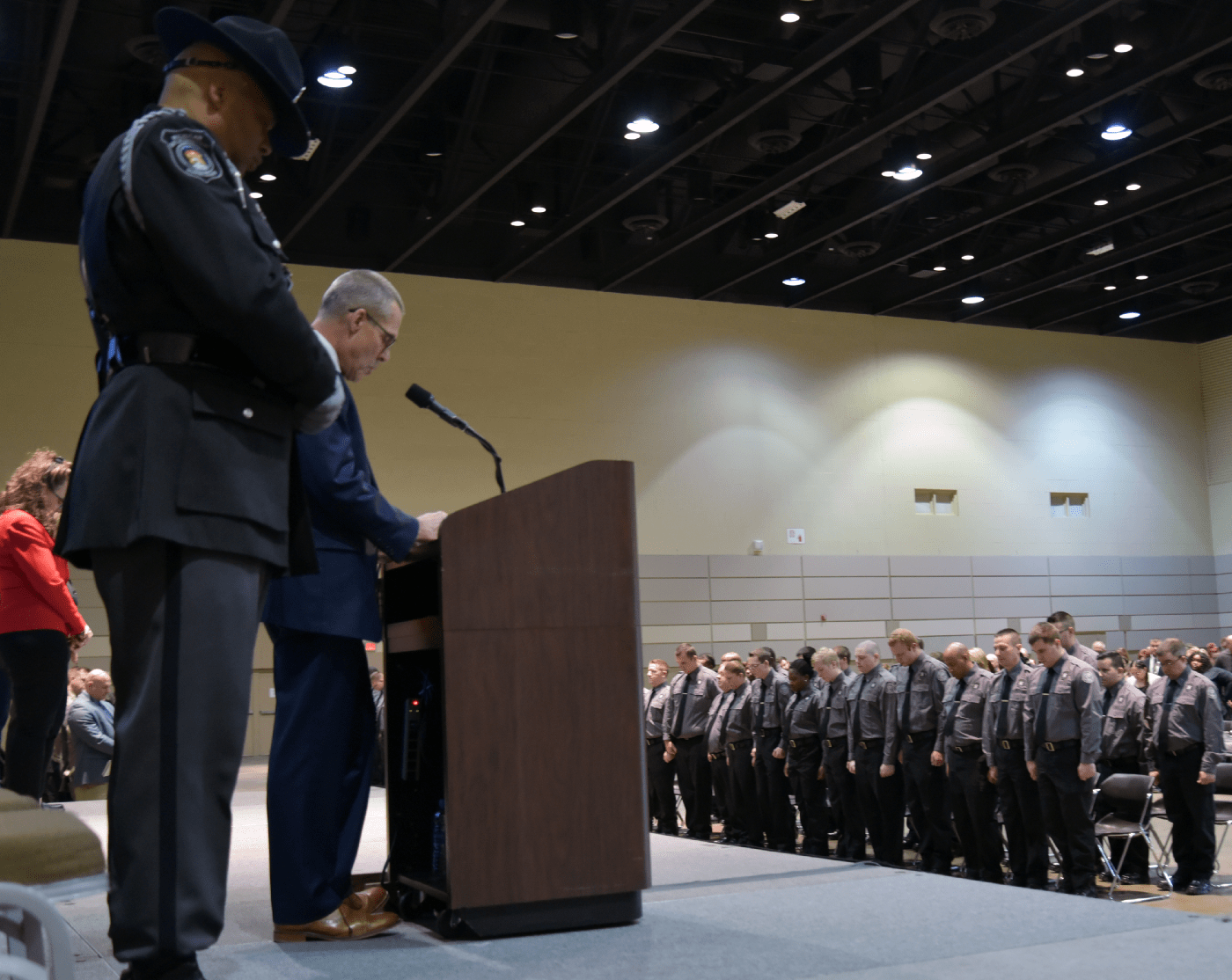 Image of MDOC Chaplain leading the prayer at a Recruit Academy graduation
