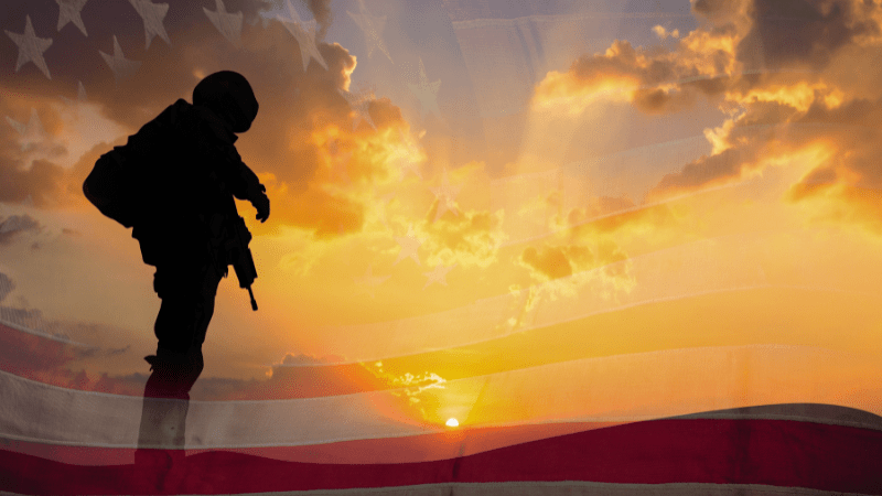 Stock photo of a soldier standing in front of a sunset
