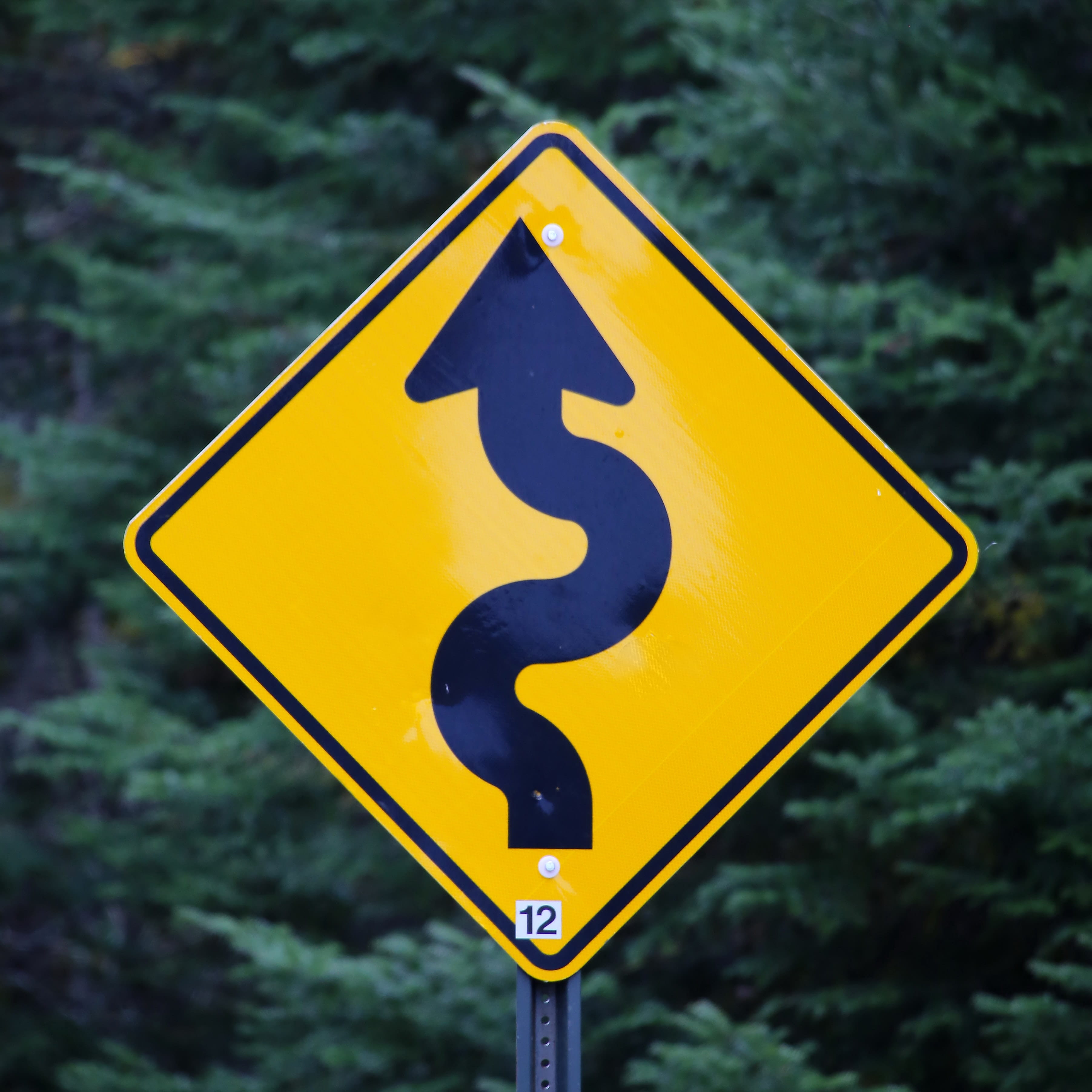Black and yellow road sign with arrow 