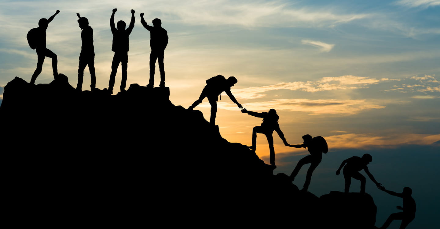 Image showing a team of people helping each other up a mountain