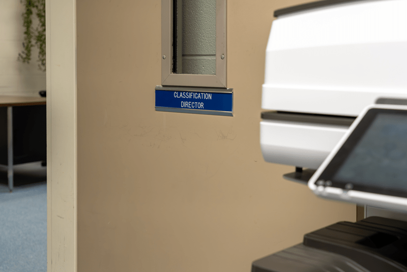 A door to an office with a name plate sign that reads 'Classification Director.'