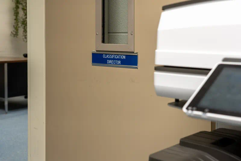 A door to an office with a name plate sign that reads 'Classification Director.'