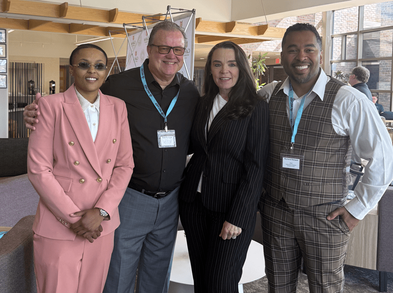 Two men and two women all standing side by side.