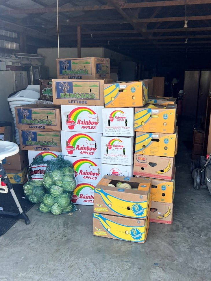 Stacked boxes of fresh produce in a warehouse.