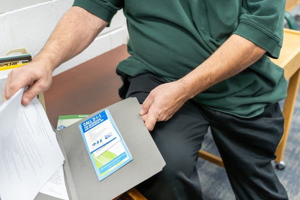Employment Counselor Christopher Dean shows resources provided to incarcerated men preparing to parole, in his office at Bellamy Creek Correctional Facility.