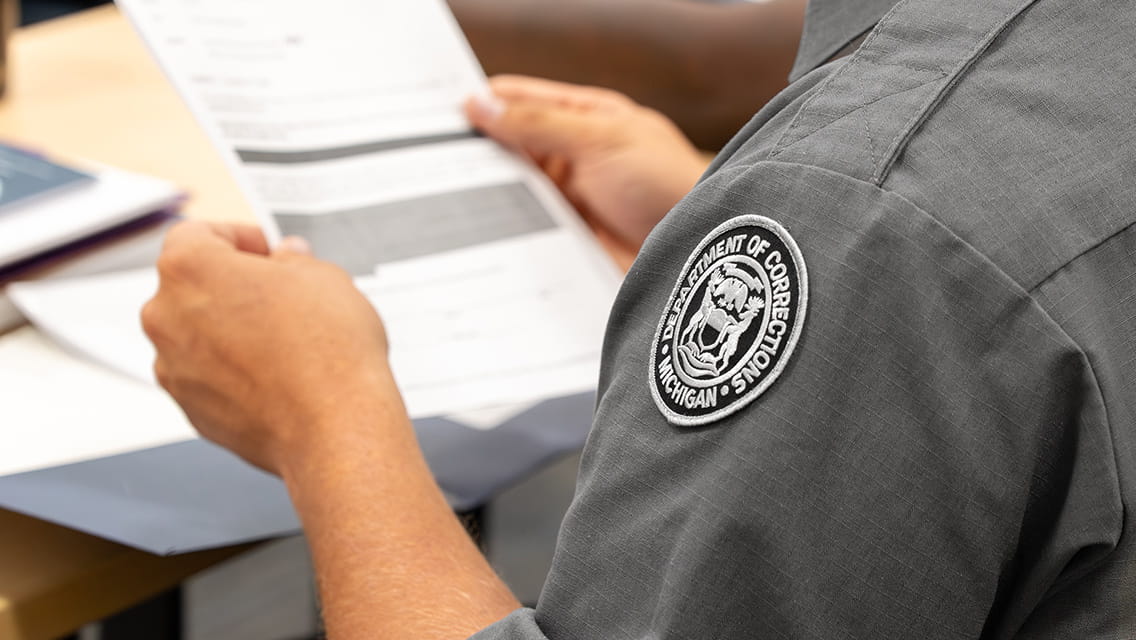 A corrections officer holding a form.