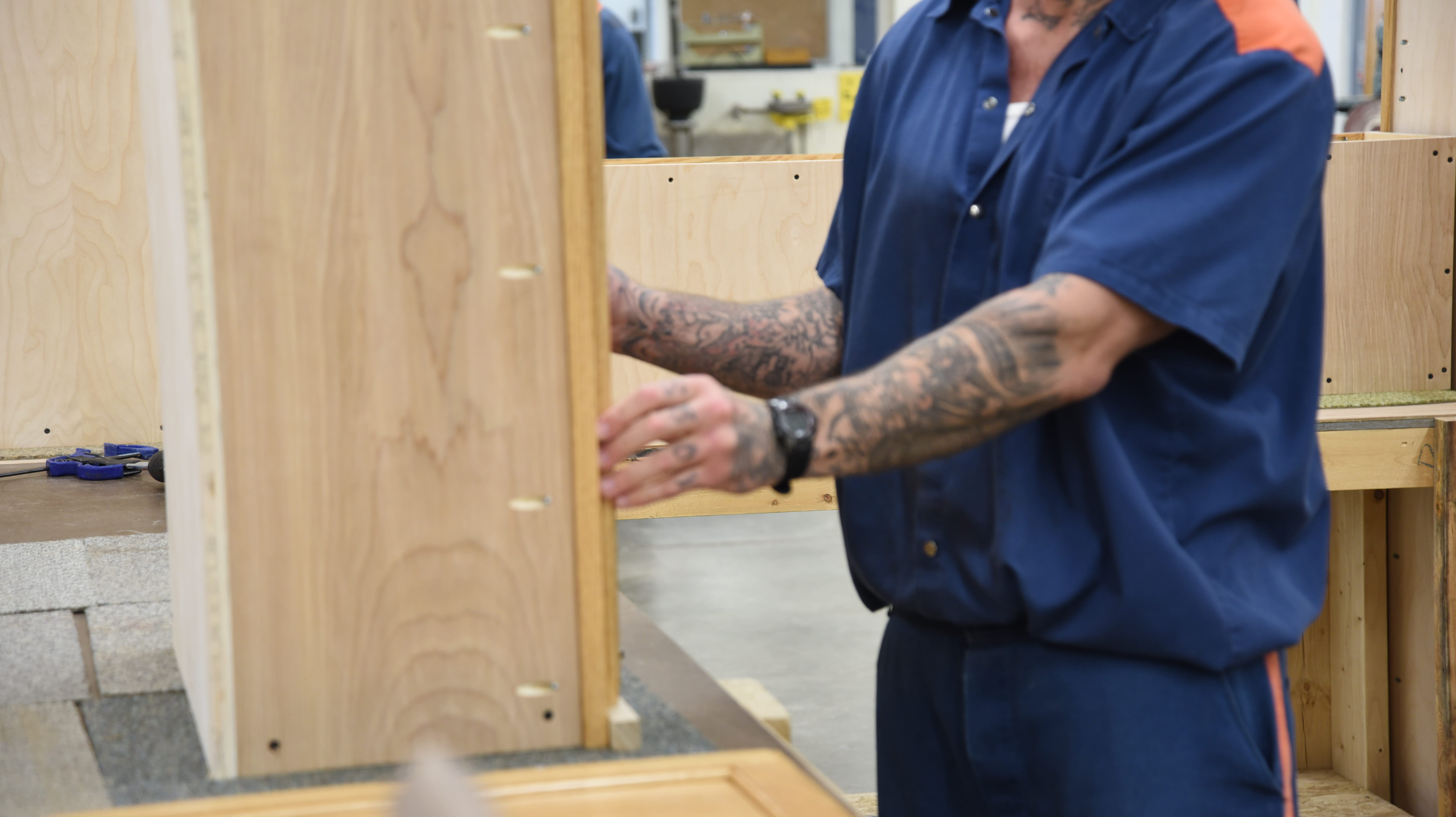 Photo of a prisoner working on a cabinet.