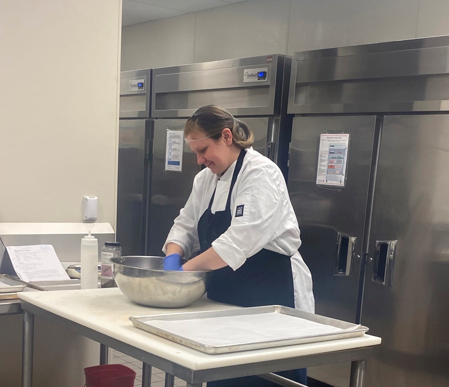 Image of female prisoner working with food in a mixing bowl