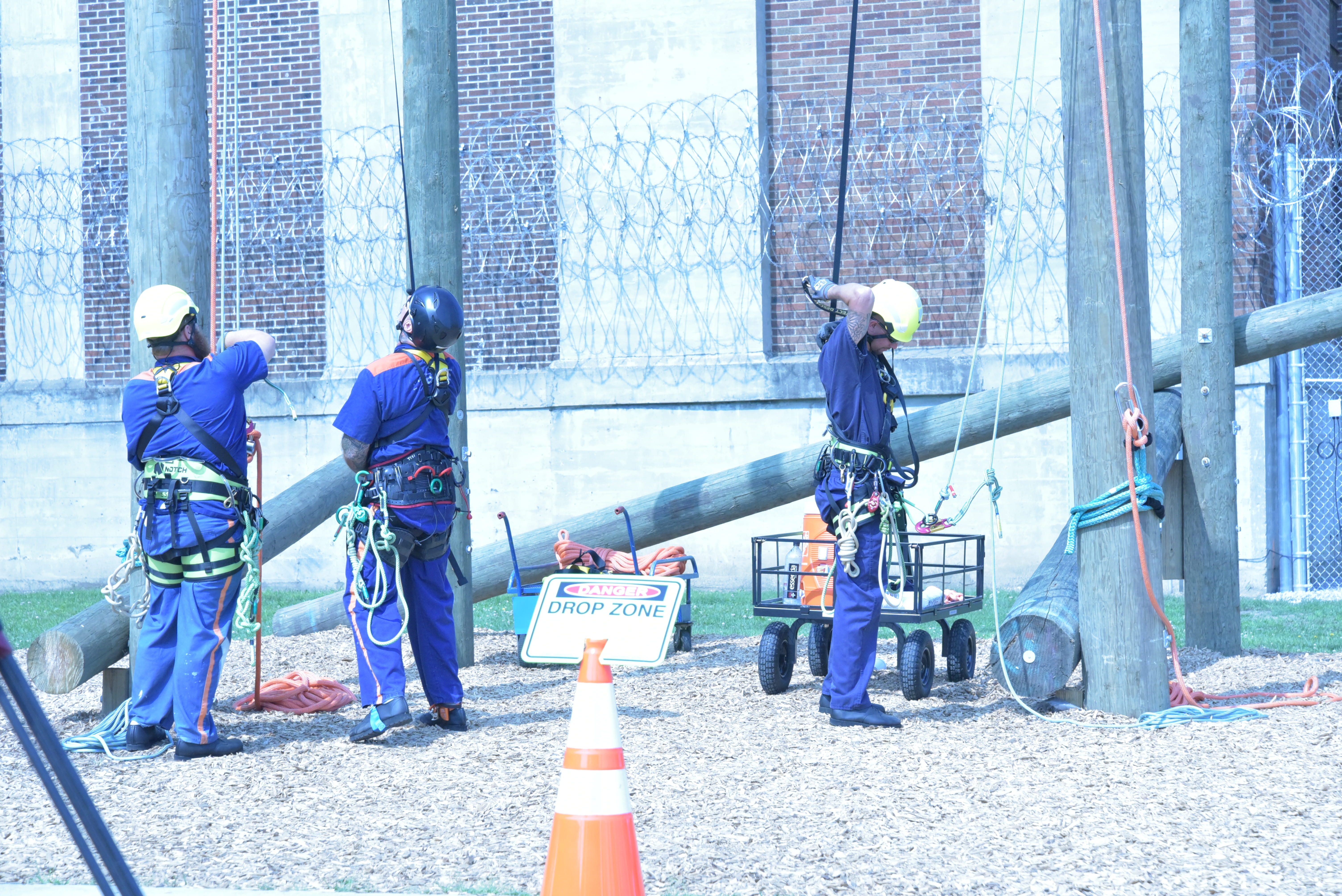 Photo of three prisoners putting on their climbing gear.