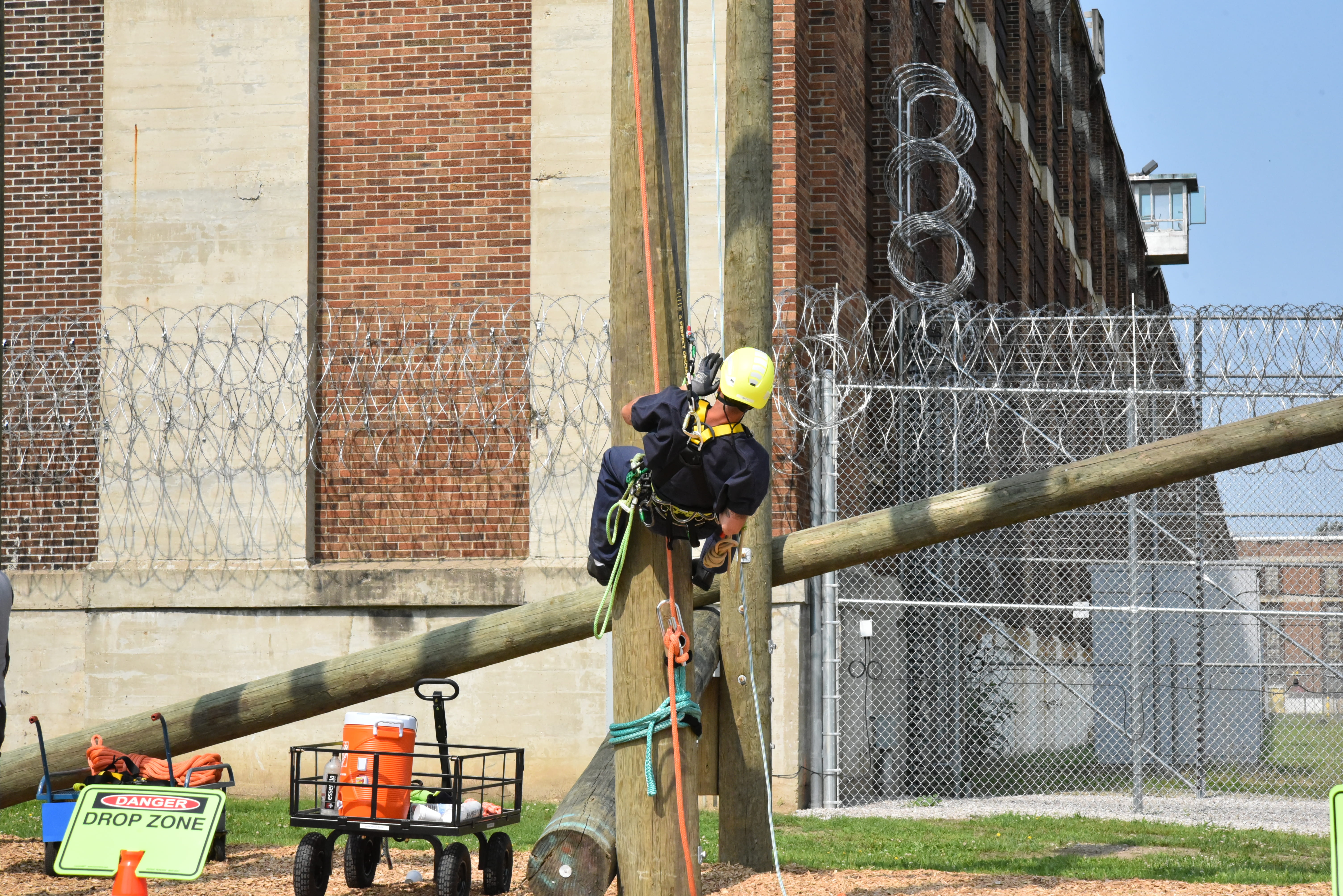 Photo of a prisoner beginning to climb a pole.
