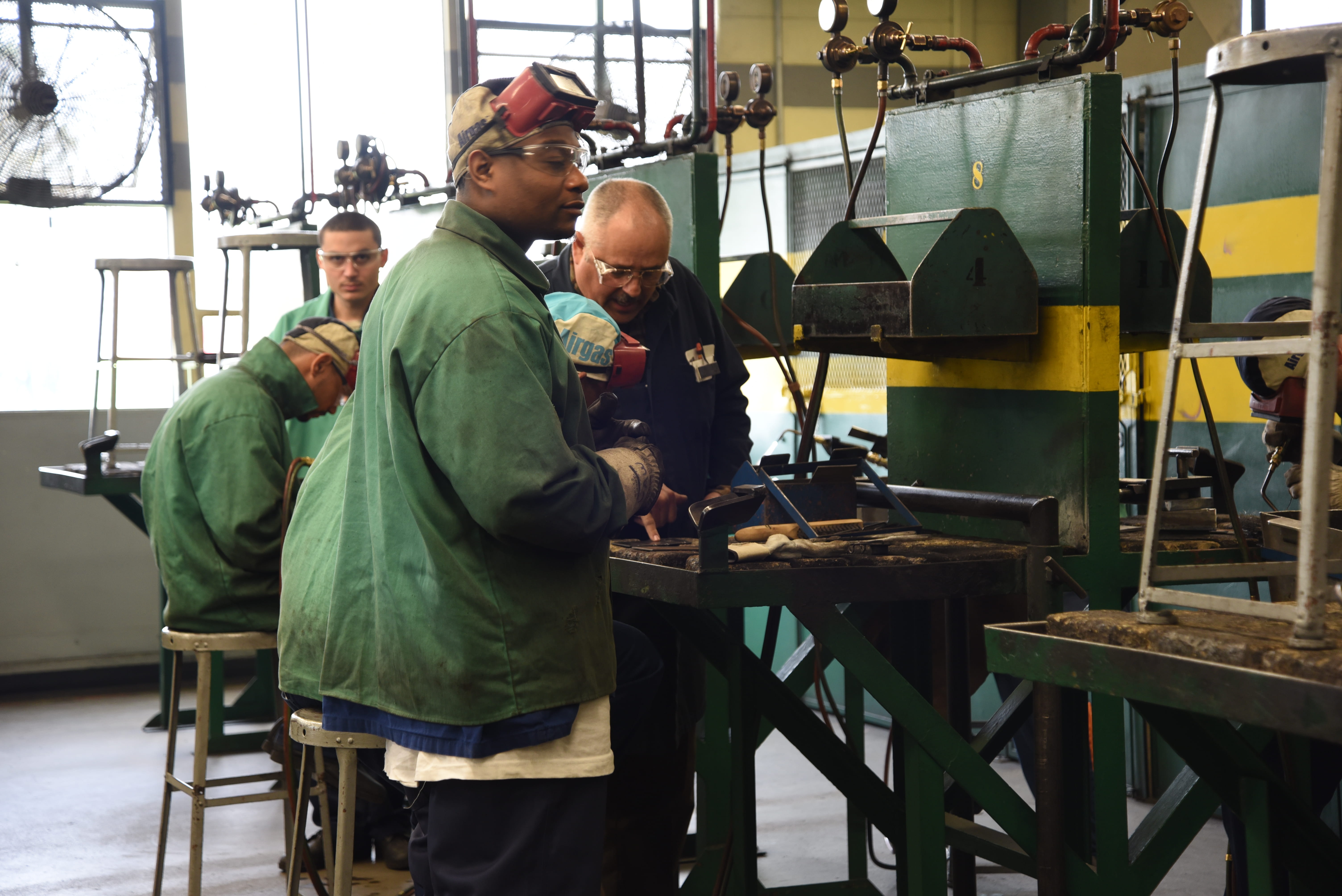 Photo of prisoners using welding equipment.