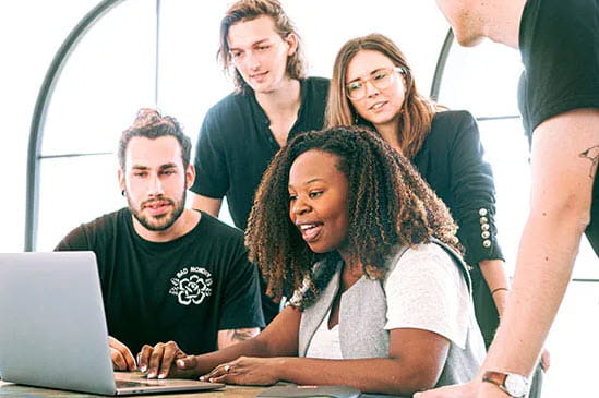 Group of people around a computer talking