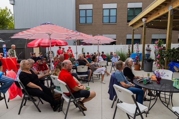 Veterans sitting on a concrete patio during a party.