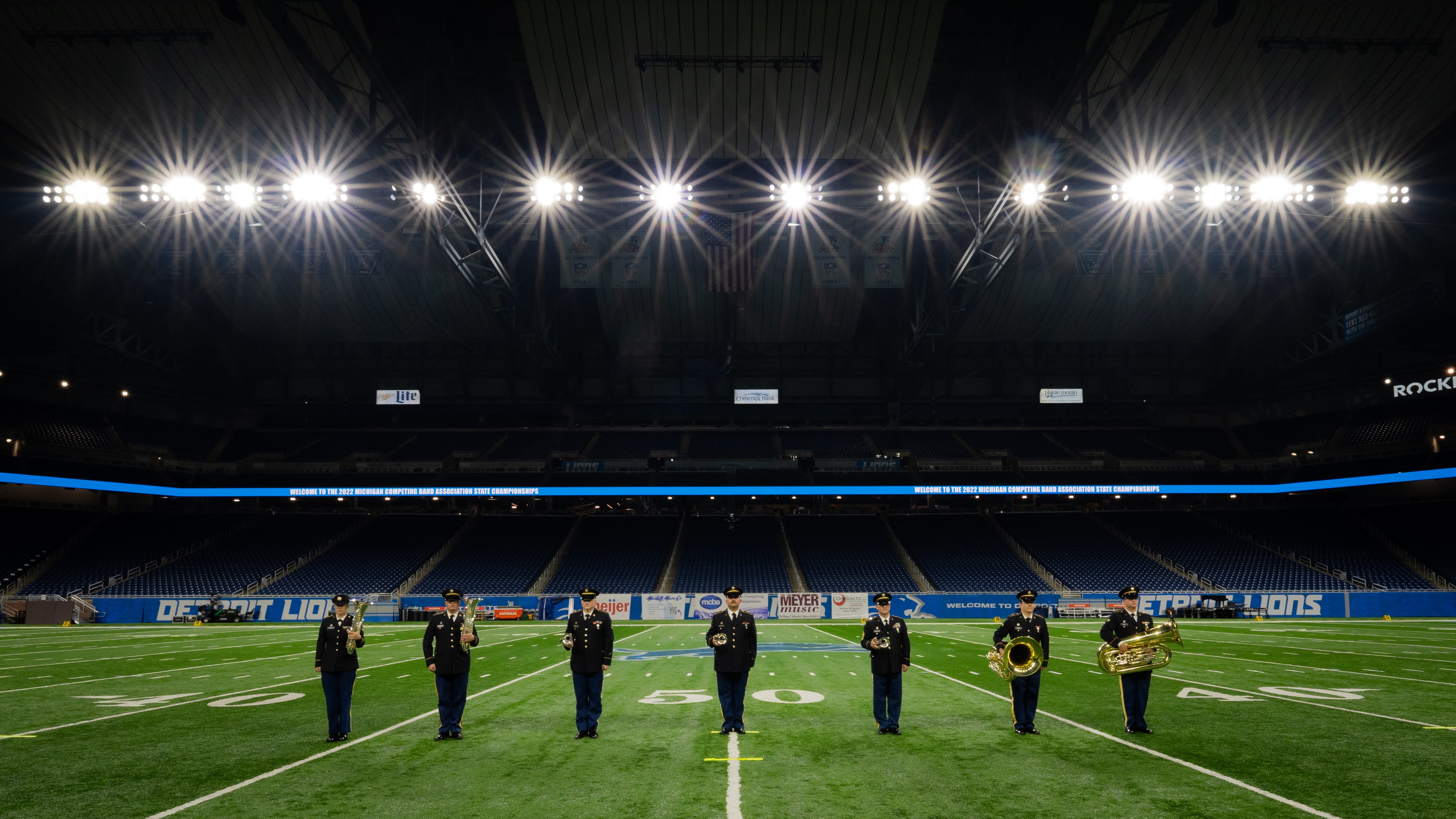 service members standing on football field