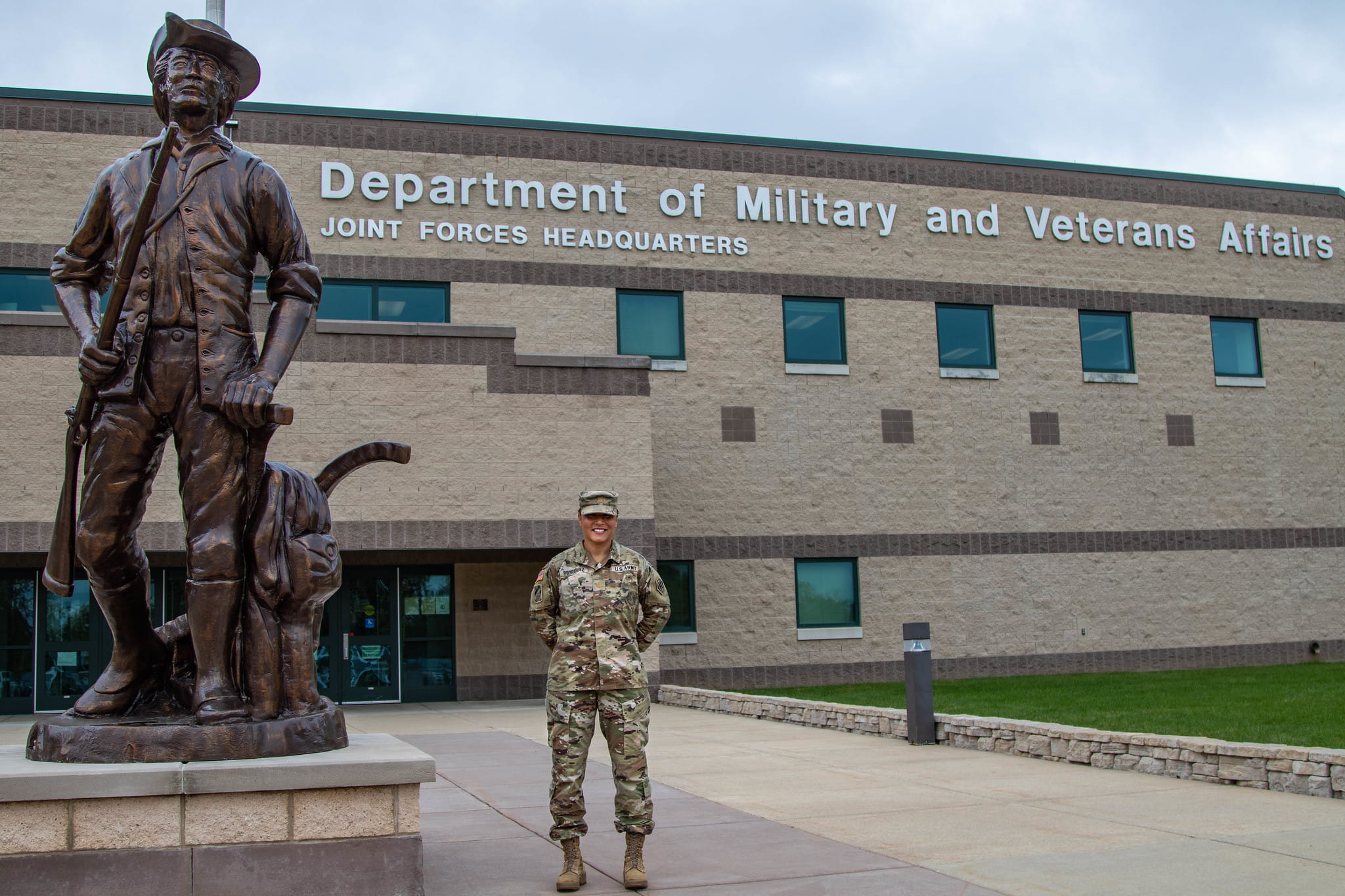 MING member standing in uniform in front of an office building