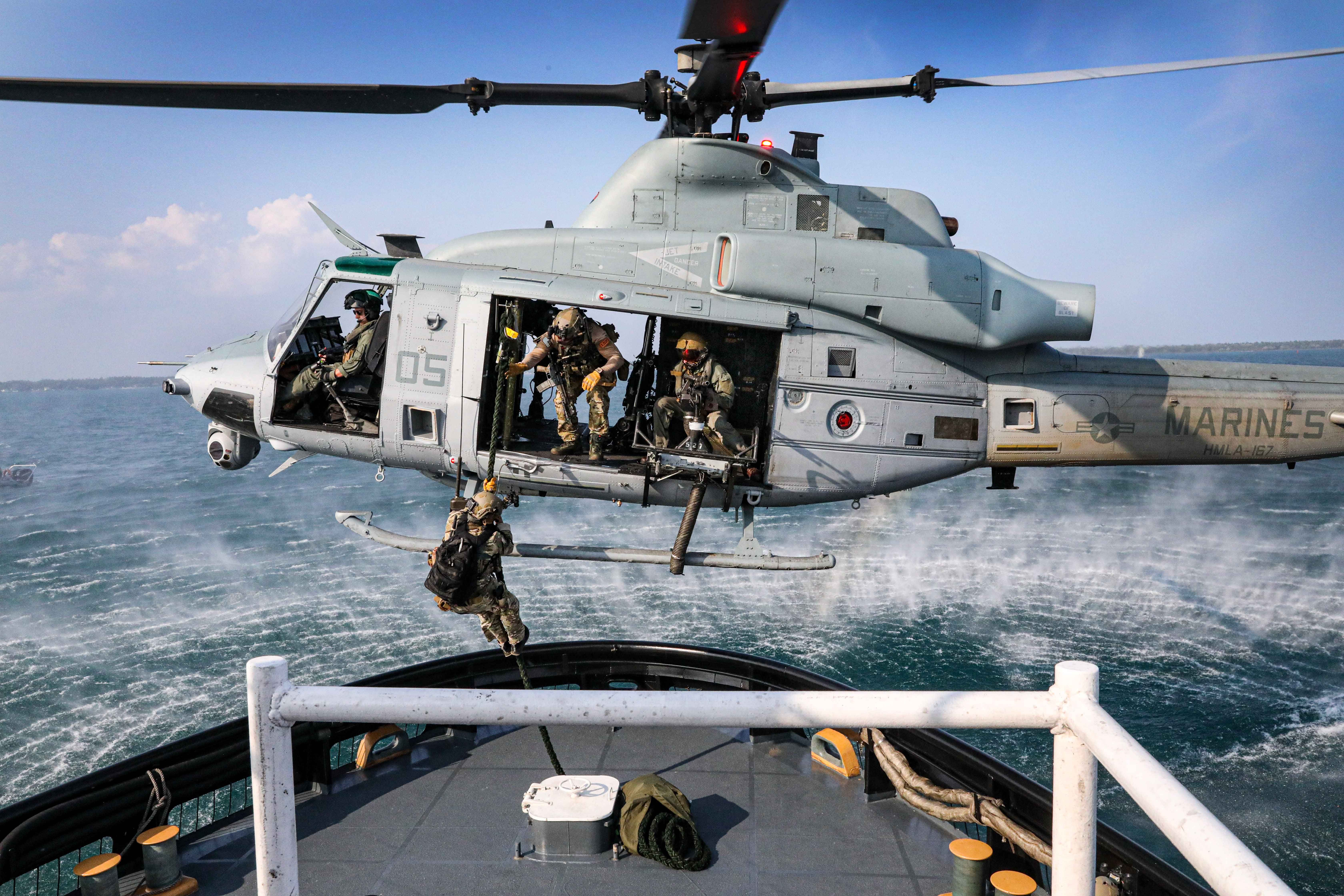 helicopter with soldiers jumping onto ship